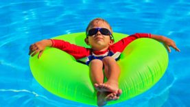 little boy in life ring having fun at beach