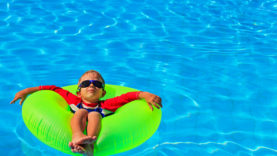 little boy in life ring having fun at beach