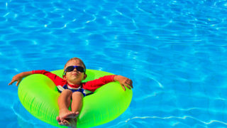 little boy in life ring having fun at beach